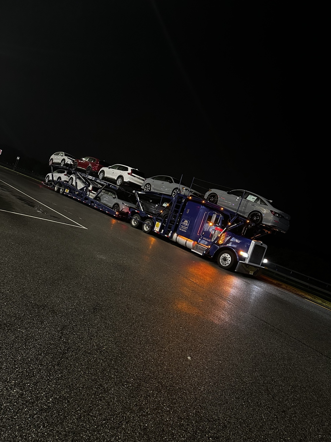 Golden Auto Transport loaded car carrier at night